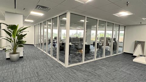 Glass office partitions meeting at a corner, installed by Stonewing