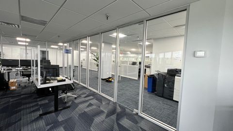 Interior glass partitions and doors dividing offices in a commercial workspace