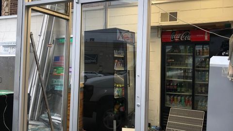 Damaged commercial storefront door frame before repair, with the glass removed